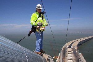 Photographer Bill Hall captured Caltrans Transportation Engineer Matt Bruce inspecting the cable band installation of the San Francisco-Oakland Bay Bridge. American Bridge Fluor completed the cable band installation Matt inspected atop the new main cable of the self-anchored suspension structure.