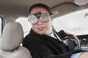 A driver wears vision impairment goggles while trying to navigate a car through an Idaho State Police closed track as part of a highway safety impaired-driving demonstration. The Idaho Transportation Department helps provide funds to purchase educational tools for law enforcement agencies to use with community outreach efforts.