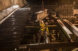 Workers install I-Beams for the construction of a new bridge over State Route 4 at the Contra Loma site.
