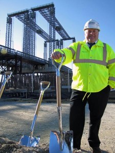 MassDOT Deputy Chief Engineer for Construction, Mike McGrath, in front of the temporary Fore River Bridge. This bridge, which crosses a major shipping channel just south of Boston, is being replaced in one of MassDOT's Mega Projects. The new bridge will improve mobility for motor vehicles and ships.