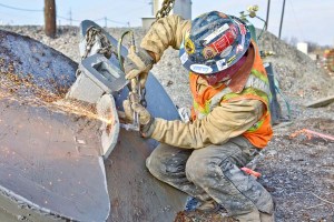 A construction worker wields a cutting torch while working on an Oklahoma Department of Transportation project to construct the multimodal I-244 bridge over the Arkansas River in Tulsa. The first of its kind in Oklahoma, this double-decker bridge incorporates highway lanes on top, dedicated future passenger rail lines underneath, along with an area for bicycle and pedestrian traffic.