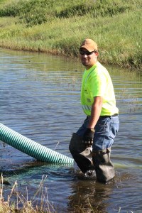 Matt Vobr, Highway Maintenance Worker from the Winner area, isn't afraid to get wet to get the job done! Matt is monitoring a pipe being used to drain a ditch to get to a plugged culvert that was causing flooding on Highway 47 in south central South Dakota.
