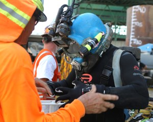 A diver prepares to perform an underwater inspection of the pilings of the Commodore Schuler F. Heim replacement Bridge. The old bridge is the last vertical-lift bridge that crosses the Cerritos Channel in the Port of Los Angeles.