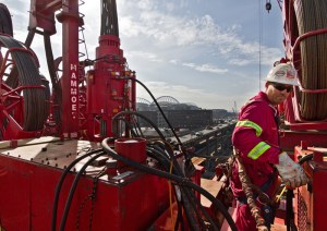 Chris Solan, an ironworker with Mammoet USA, ensures that a 105-foot-tall modular lift tower is running smoothly before it hoists sections of the SR 99 tunneling machine to the surface for repairs. The custom-engineered tower in downtown Seattle is rigged with 7 miles of steel cable.